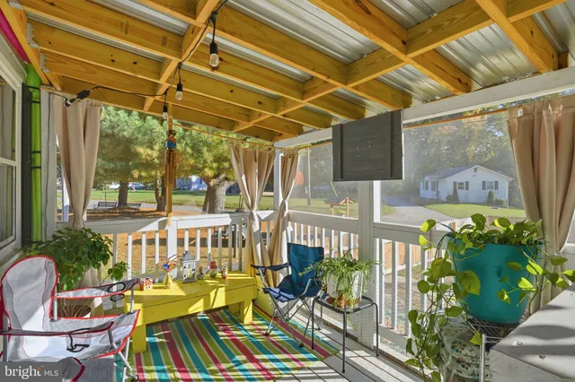 a view of a patio with table and chairs potted plants and floor to ceiling window
