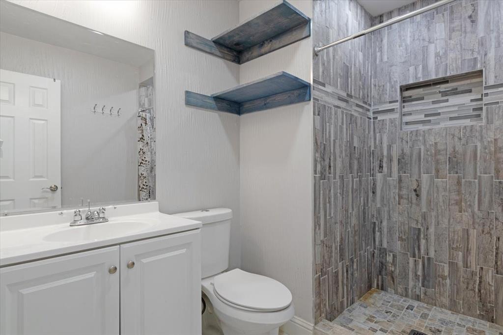 112 North Masters Drive Dallas, TX 75217 - Photo 13 of 22 a bathroom with a sink a toilet and shower