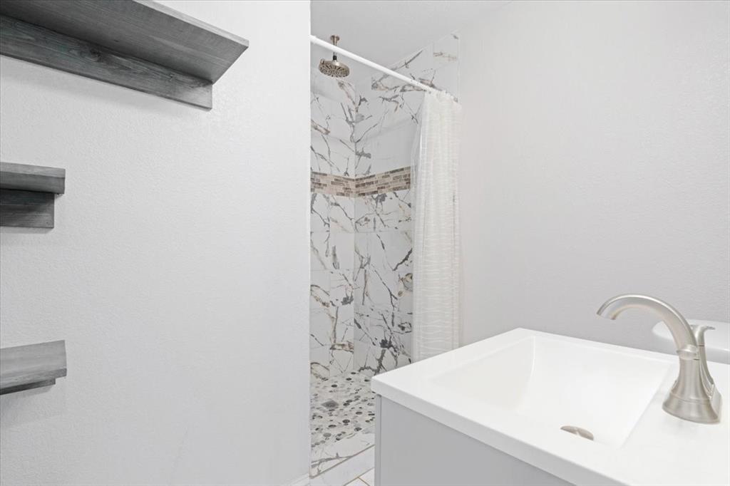 112 North Masters Drive Dallas, TX 75217 - Photo 14 of 22 a bathroom with a sink and a shower