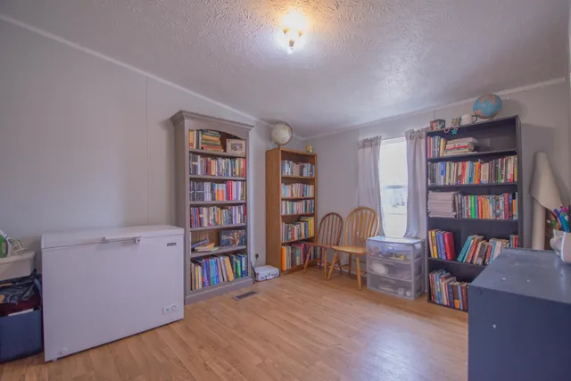 a view of a workspace with furniture and bookshelf
