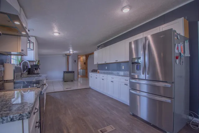 a kitchen with stainless steel appliances granite countertop a refrigerator sink and stove