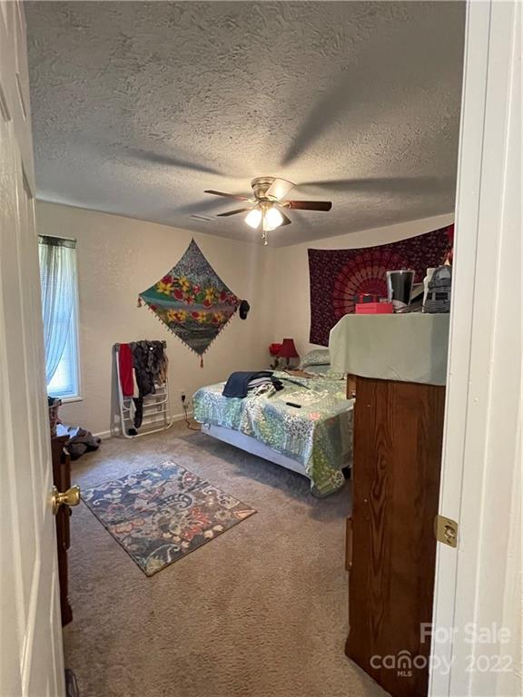 7400 R R H Road Hickory, NC 28602 - Photo 15 of 30 a bedroom with a bed and a chandelier