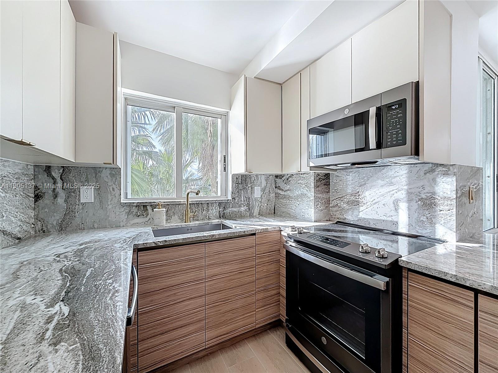 5900 Collins Avenue, Unit 508 Miami Beach, FL 33140 - Photo 11 of 39 a kitchen with stainless steel appliances granite countertop a sink stove and microwave