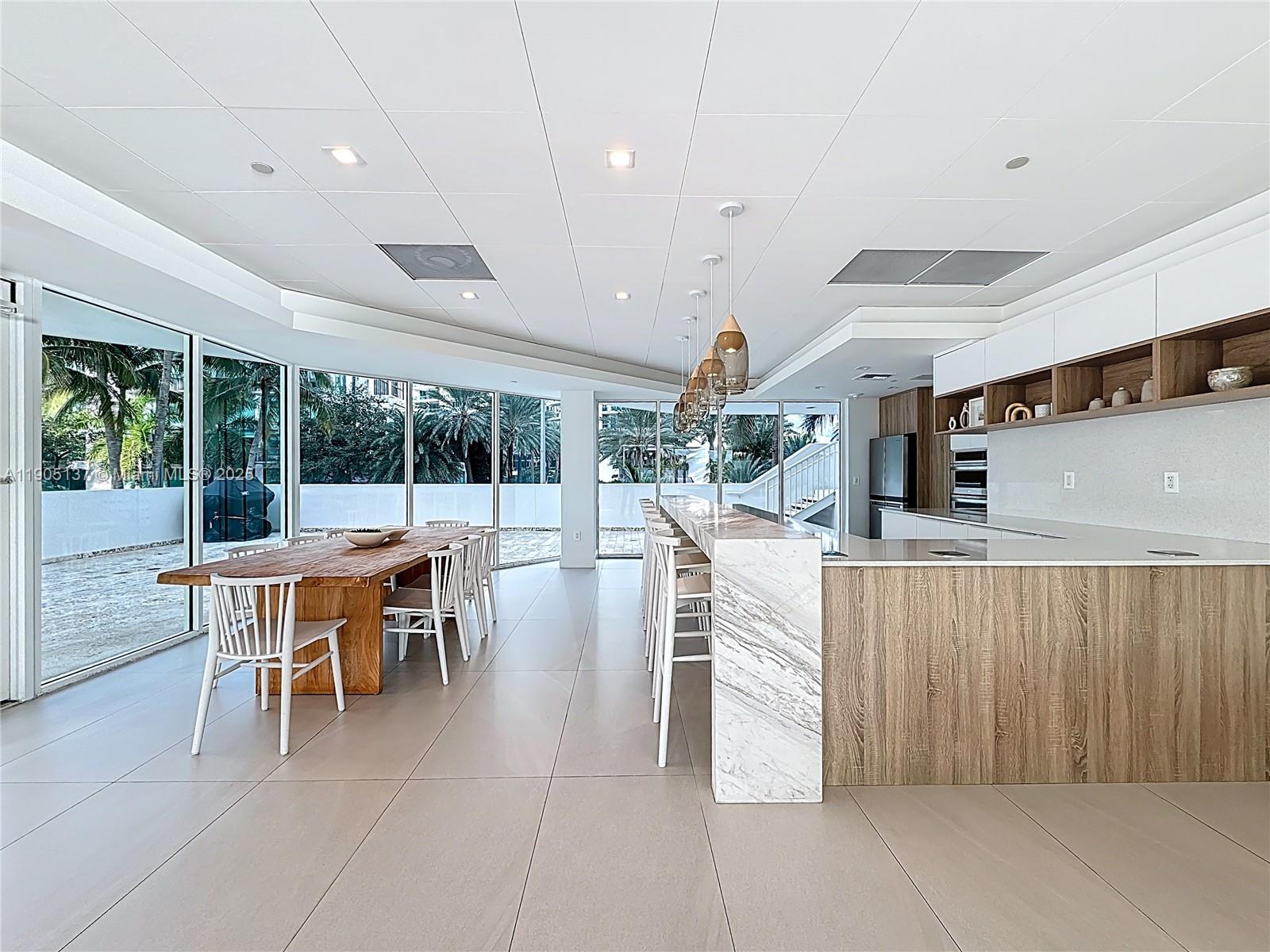 5900 Collins Avenue, Unit 508 Miami Beach, FL 33140 - Photo 29 of 39 a dining hall with stainless steel appliances kitchen island granite countertop a table and chairs