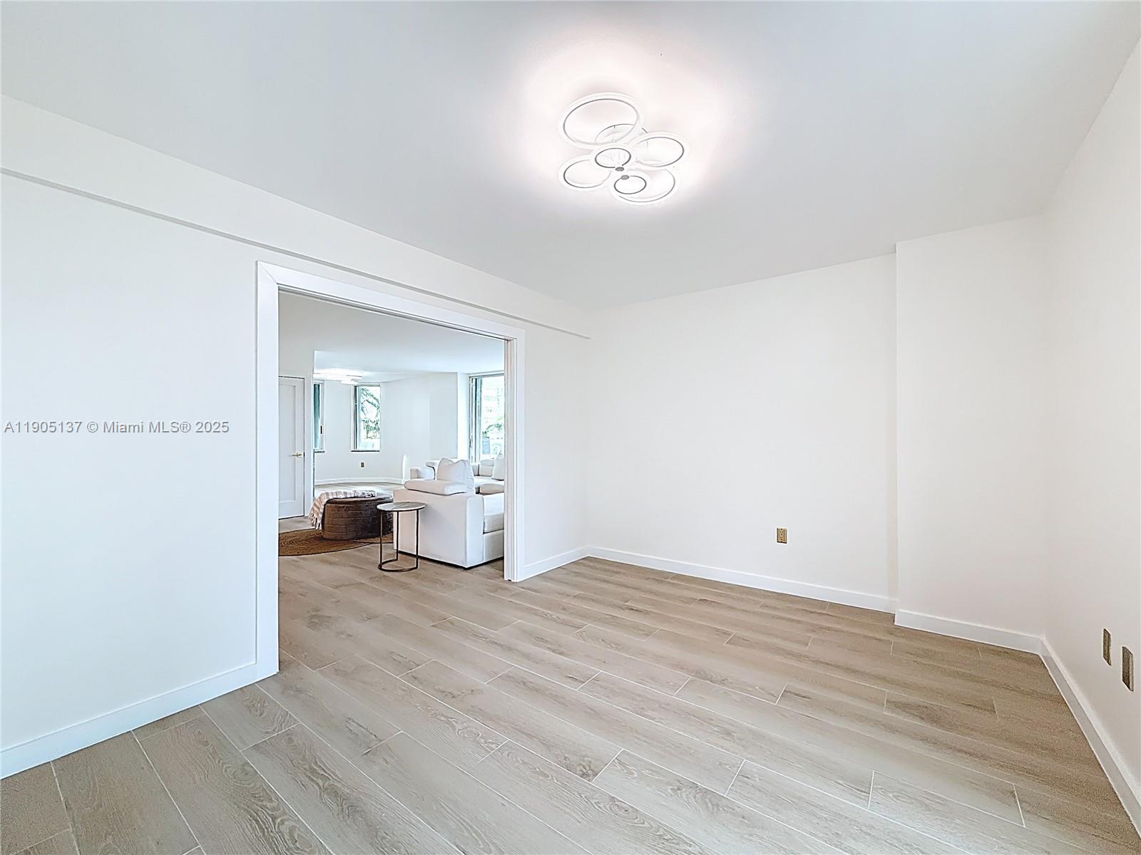 5900 Collins Avenue, Unit 508 Miami Beach, FL 33140 - Photo 7 of 39 a view of a room with wooden floor and kitchen view