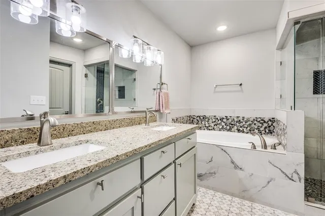 a bathroom with a granite countertop sink a mirror and shower