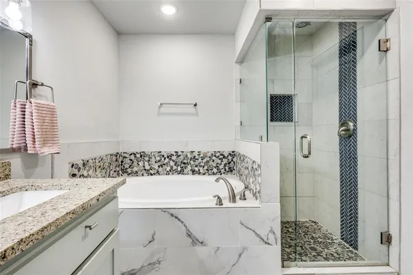 a bathroom with a granite countertop sink and a bathtub