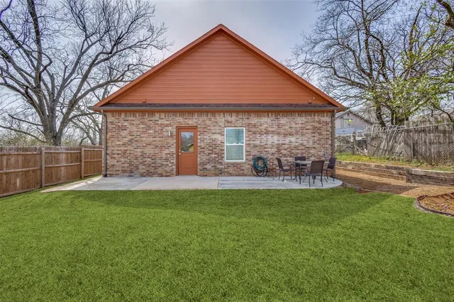 a backyard of a house with table and chairs