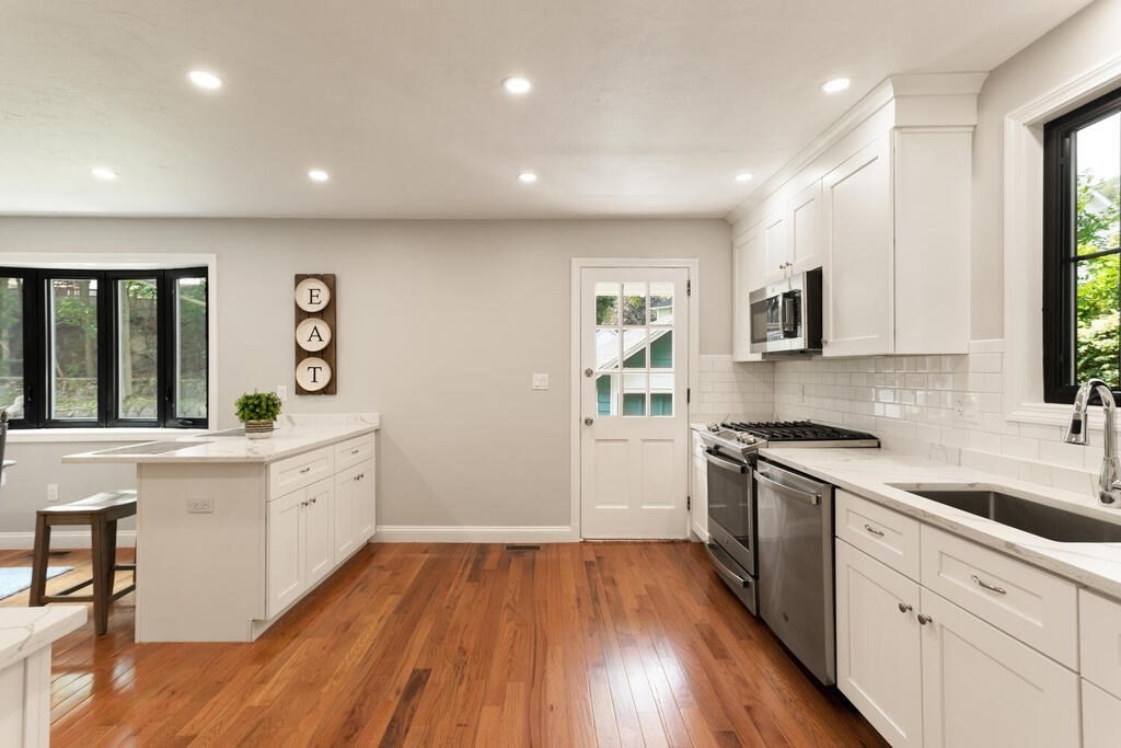 58 Maple Road Melrose, MA 02176 - Photo 13 of 34 a large kitchen with stainless steel appliances granite countertop a lot of counter space and wooden floors
