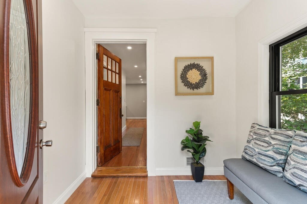 58 Maple Road Melrose, MA 02176 - Photo 5 of 34 a view of a hallway with wooden floor and a potted plant