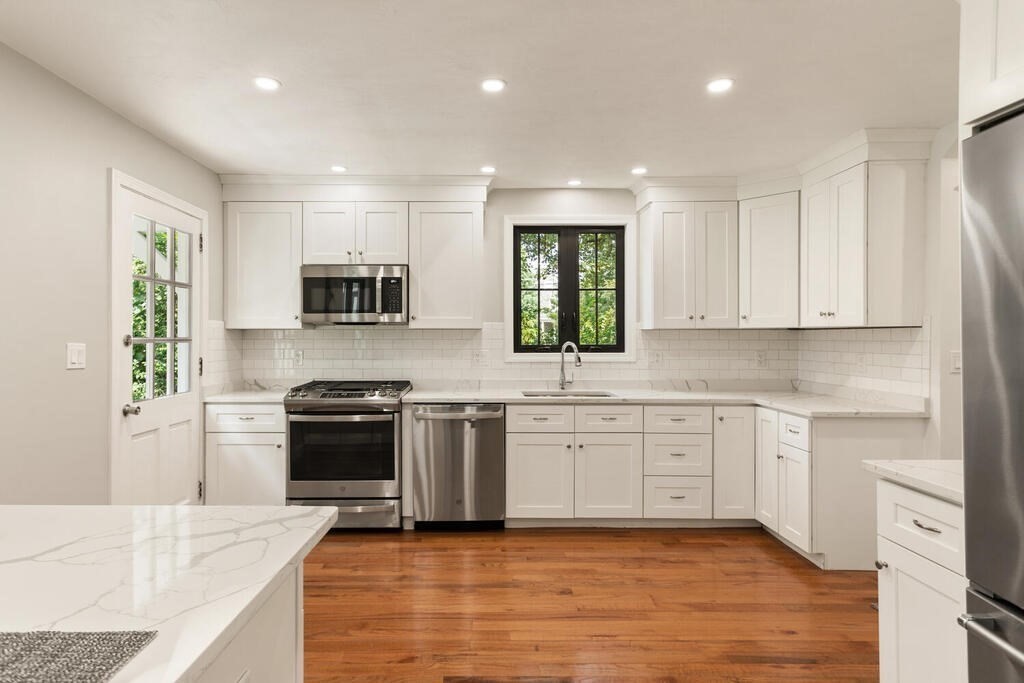 58 Maple Road Melrose, MA 02176 - Photo 10 of 34 a open kitchen with granite countertop a stove top oven a sink dishwasher and a refrigerator with wooden floor