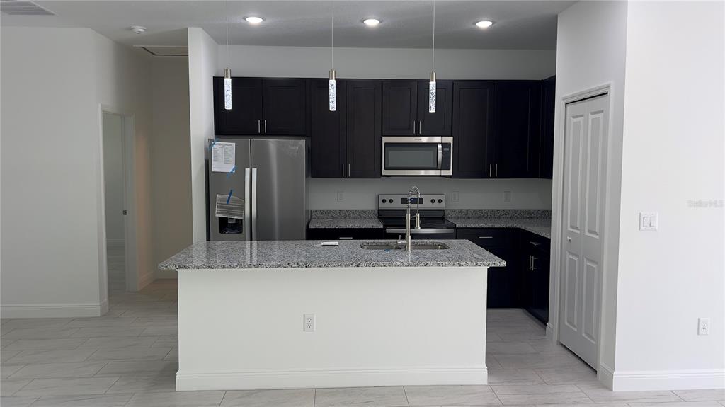 5027 Southwest 165th St Road Ocala, FL 34473 - Photo 11 of 33 a kitchen with kitchen island stainless steel appliances a sink and counter top
