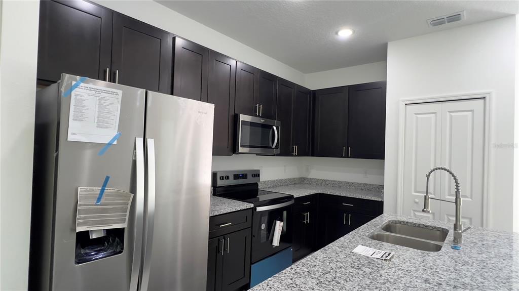 5027 Southwest 165th St Road Ocala, FL 34473 - Photo 14 of 33 a kitchen with granite countertop a refrigerator and a sink