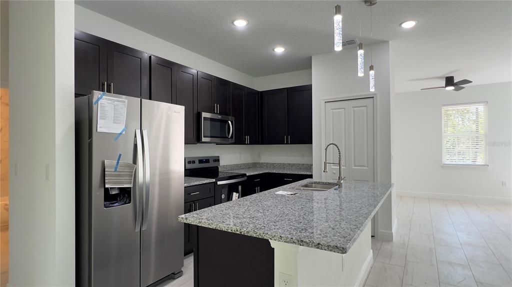 5027 Southwest 165th St Road Ocala, FL 34473 - Photo 15 of 33 a kitchen with stainless steel appliances granite countertop a refrigerator and a sink