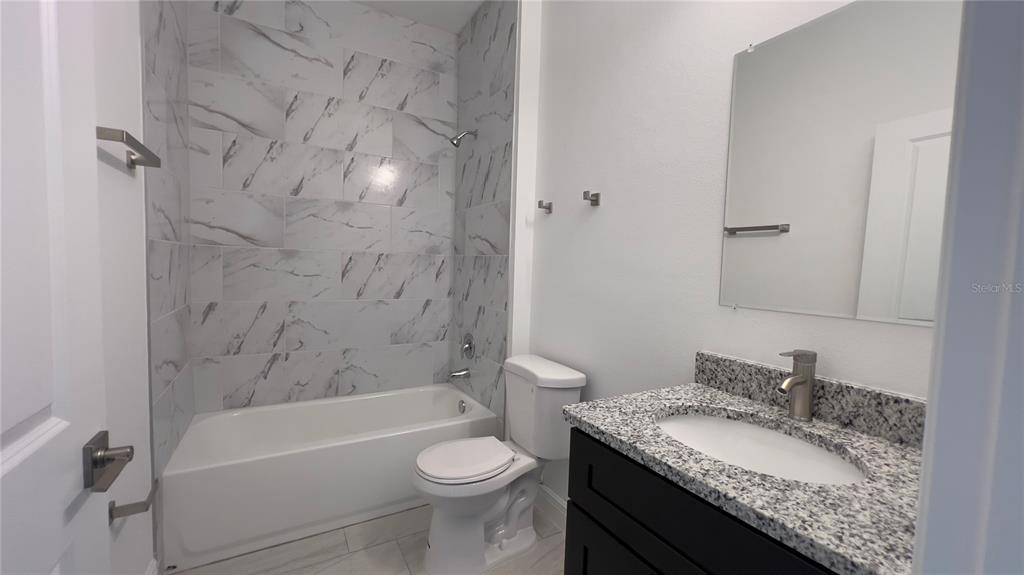 5027 Southwest 165th St Road Ocala, FL 34473 - Photo 19 of 33 a bathroom with a granite countertop sink toilet and shower