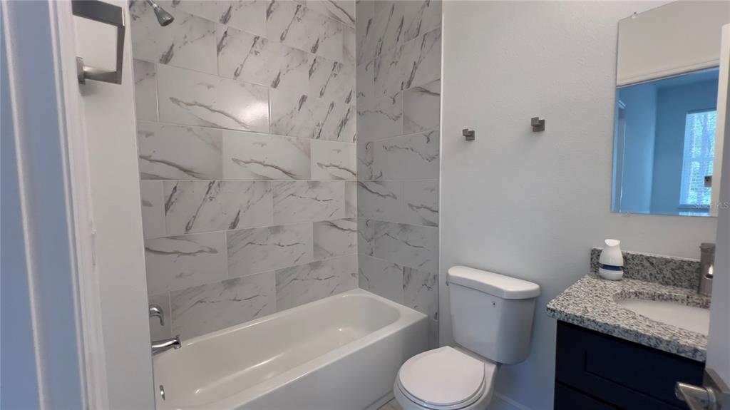 5027 Southwest 165th St Road Ocala, FL 34473 - Photo 26 of 33 a bathroom with a granite countertop toilet sink and bathtub