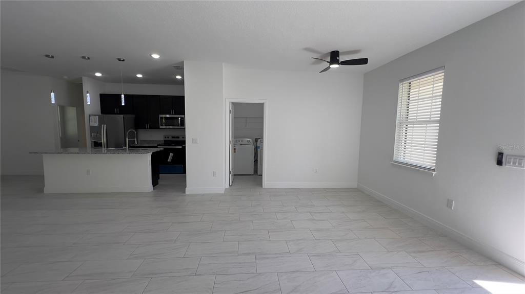5027 Southwest 165th St Road Ocala, FL 34473 - Photo 4 of 33 an empty room with kitchen view and a window