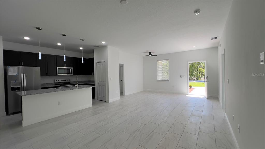 5027 Southwest 165th St Road Ocala, FL 34473 - Photo 6 of 33 a view of kitchen with kitchen island granite countertop stainless steel appliances stove refrigerator and microwave