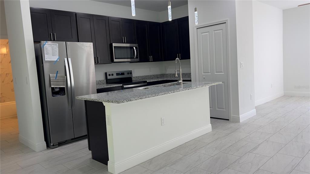 5027 Southwest 165th St Road Ocala, FL 34473 - Photo 9 of 33 a kitchen with stainless steel appliances granite countertop a refrigerator a stove top oven a sink and dishwasher