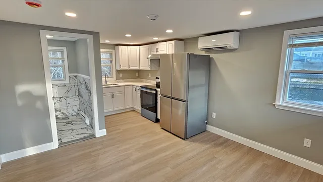 a kitchen with granite countertop white cabinets and stainless steel appliances