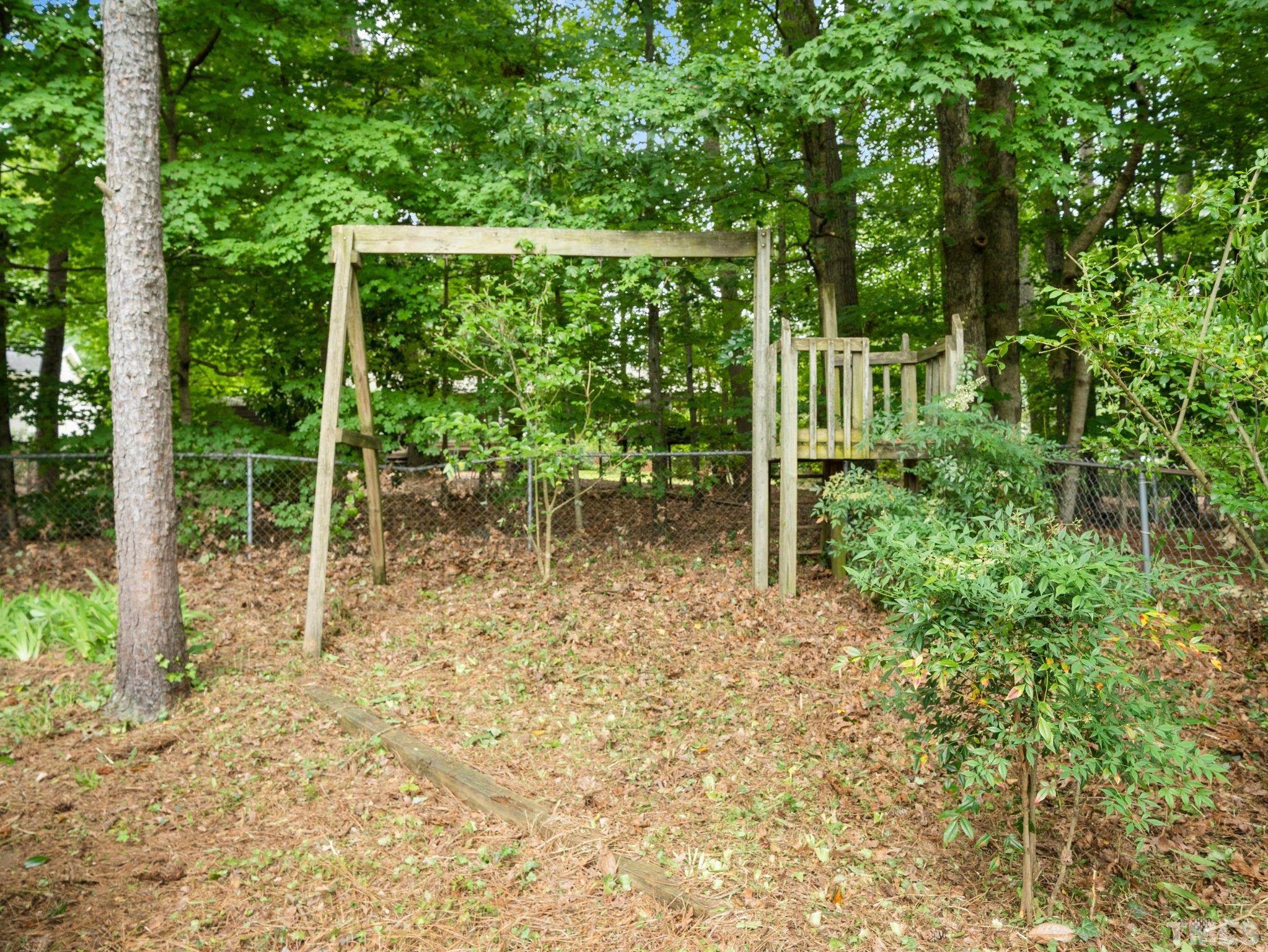 1413 Ashburton Road Raleigh, NC 27606 - Photo 23 of 27 a backyard of a house with lots of green space and plants