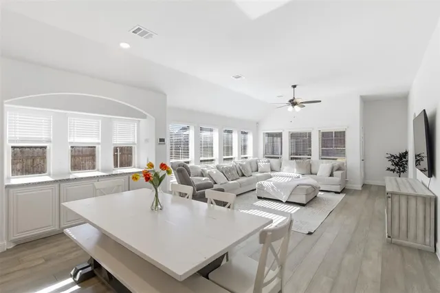 a living room with furniture large window and wooden floor