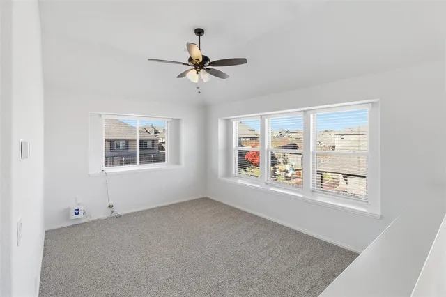 a view of a room with a ceiling fan and window