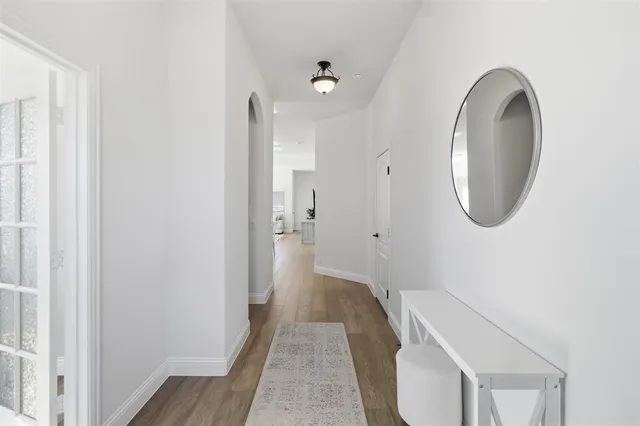 a view of a hallway with wooden floor and a window
