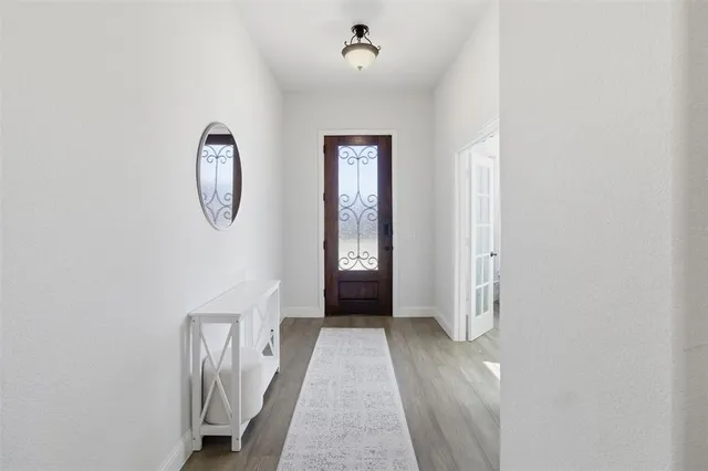 a kitchen with stainless steel appliances granite countertop a sink a stove a refrigerator and white cabinets