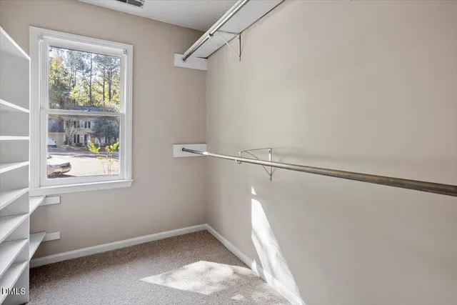 a view of small space with racks on the wall and a window