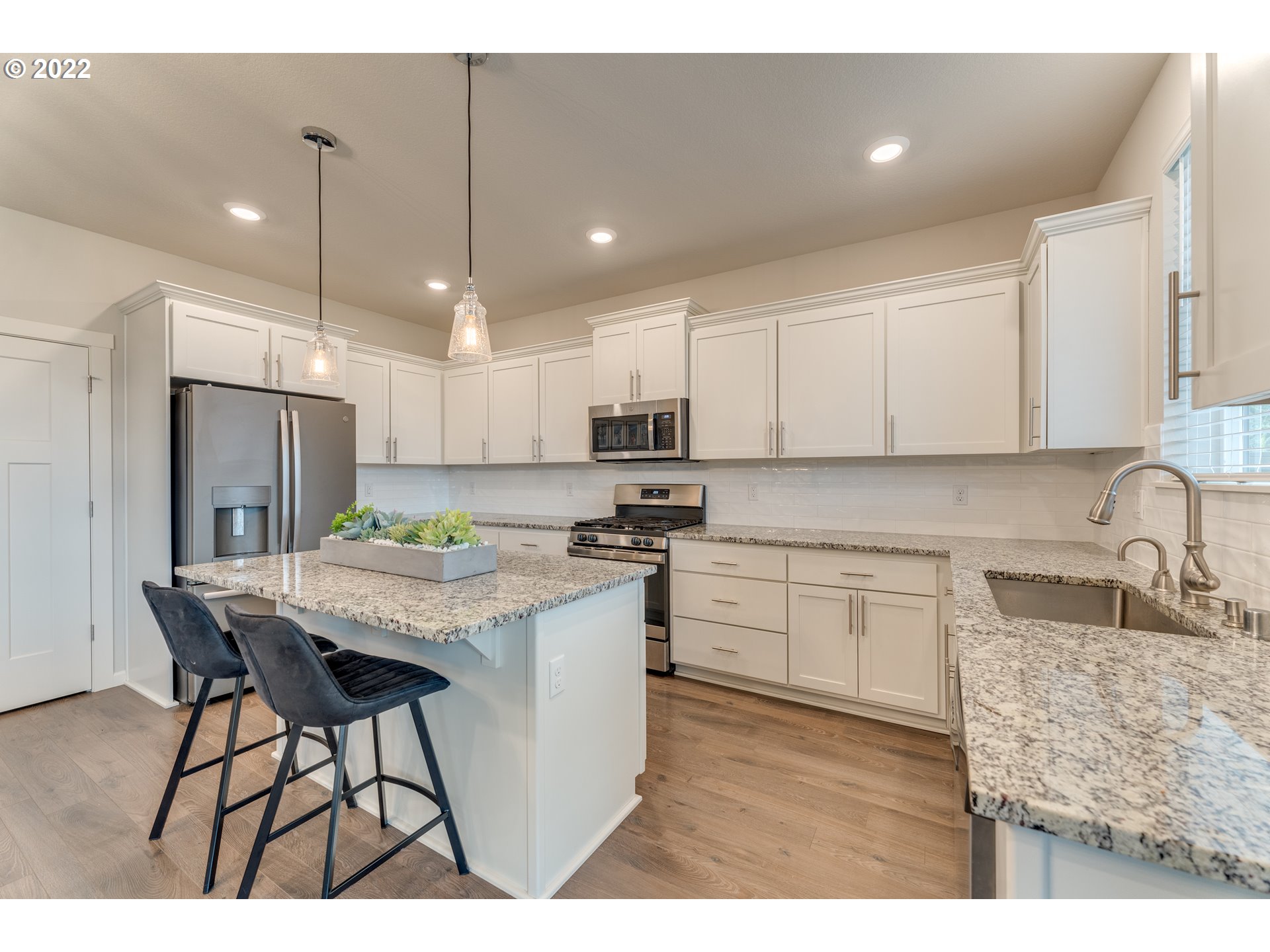 13305 Northeast 114th Way Brush Prairie, WA 98606 - Photo 7 of 31 a kitchen with kitchen island a dining table chairs sink and cabinets