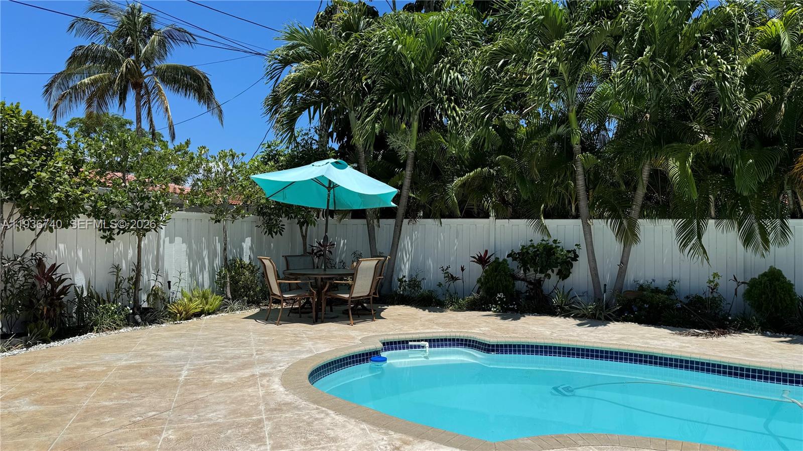 1611 71st Street Miami Beach, FL 33141 - Photo 16 of 16 a table and chairs under an umbrella in patio