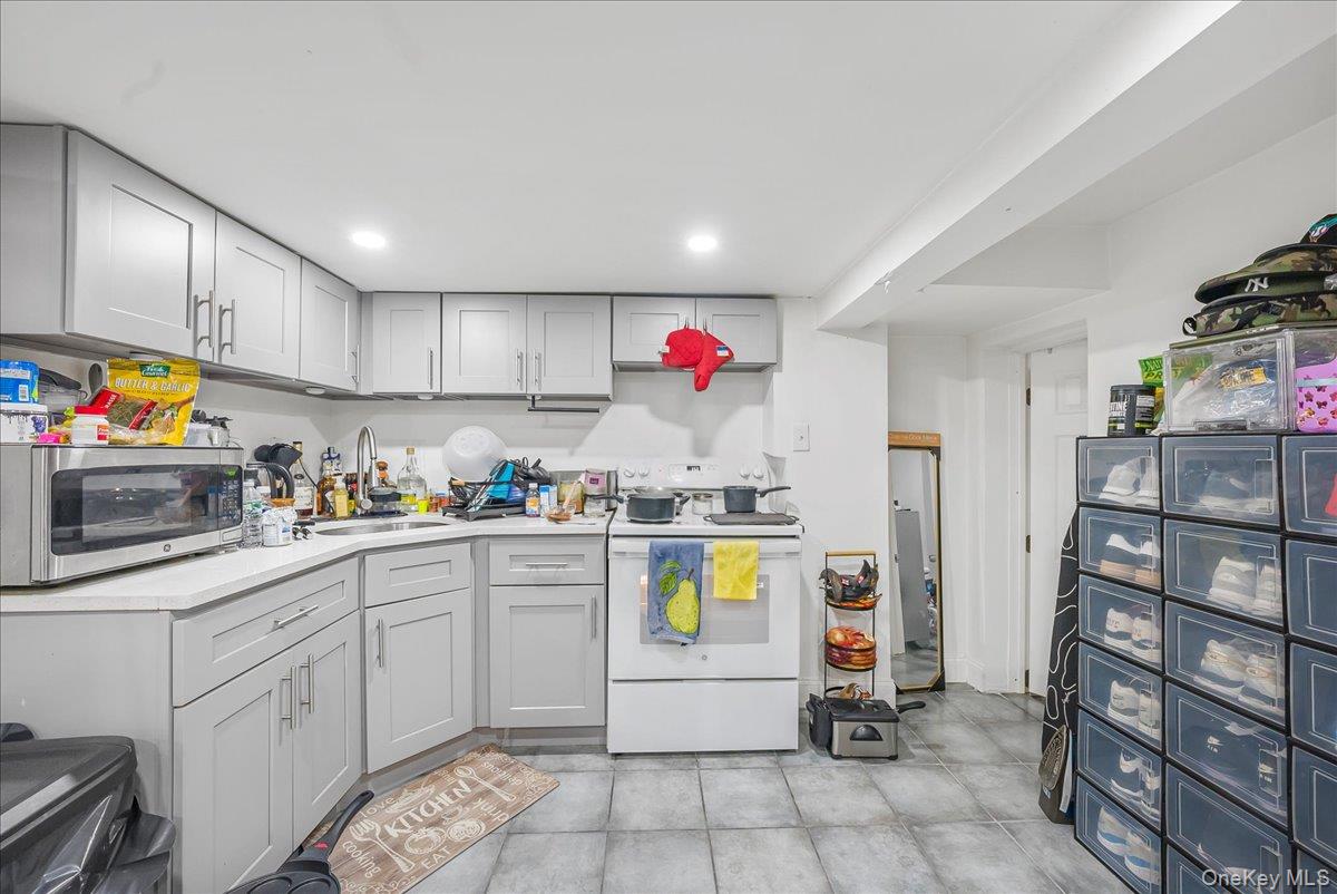 1526 Kennellworth Place Bronx, NY 10465 - Photo 16 of 37 a kitchen with stainless steel appliances granite countertop a sink cabinets and window