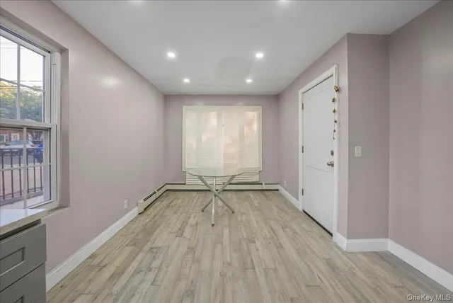 a room with wooden floor and white cabinets