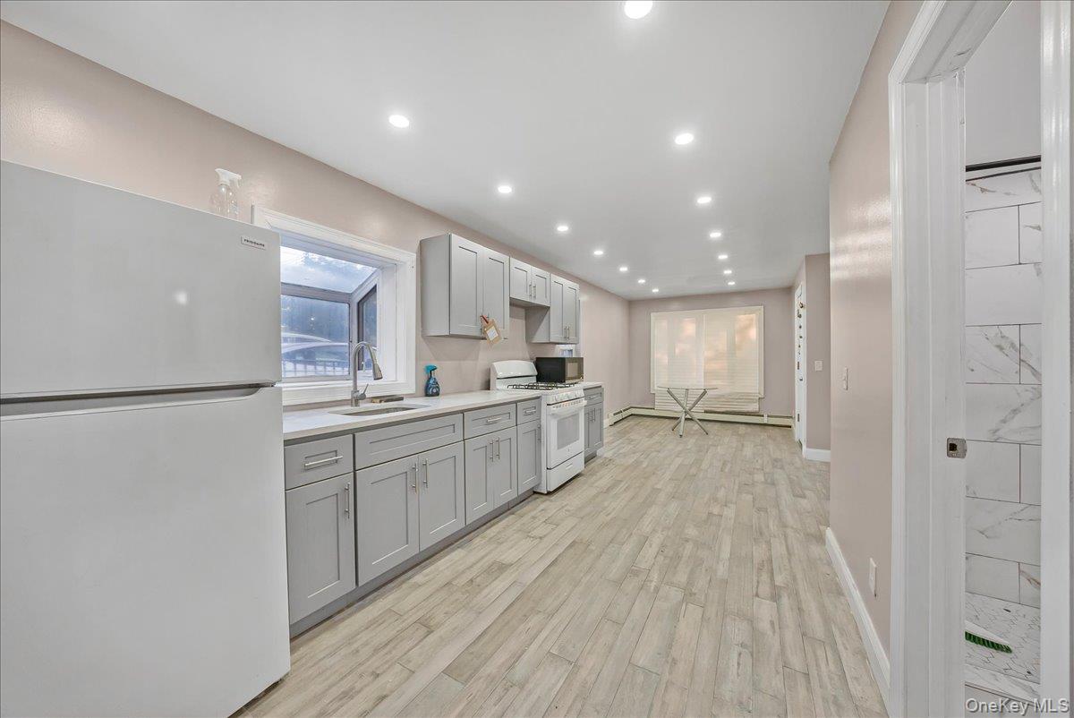 1526 Kennellworth Place Bronx, NY 10465 - Photo 28 of 37 a kitchen with white cabinets and white appliances