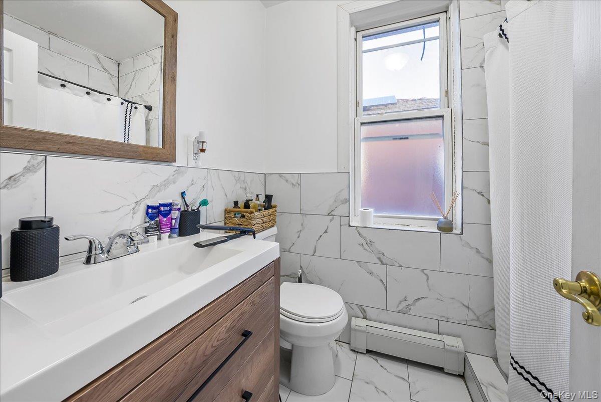 1526 Kennellworth Place Bronx, NY 10465 - Photo 37 of 37 a bathroom with a sink a toilet and shower