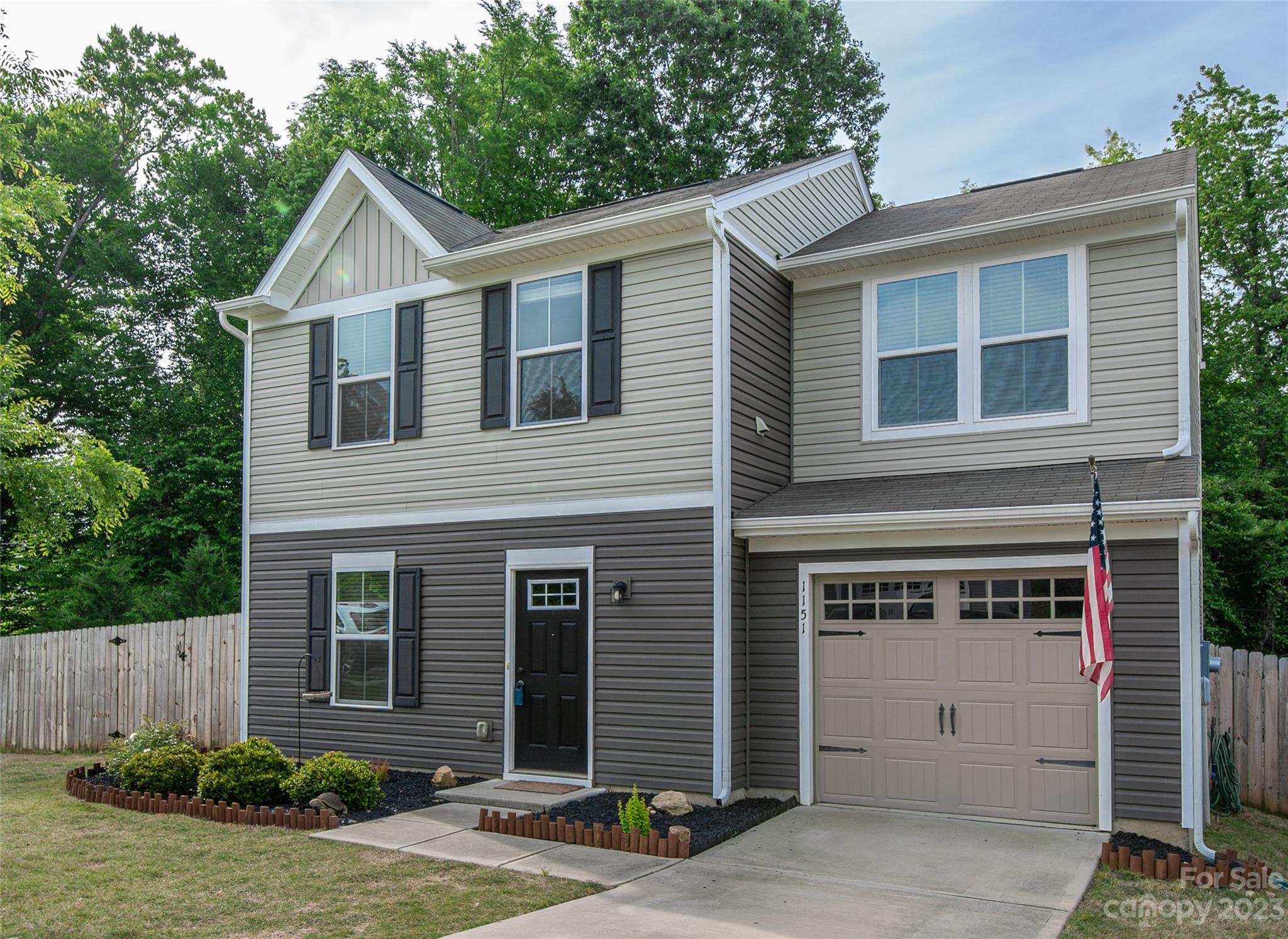 a view of a house with a yard and potted plants