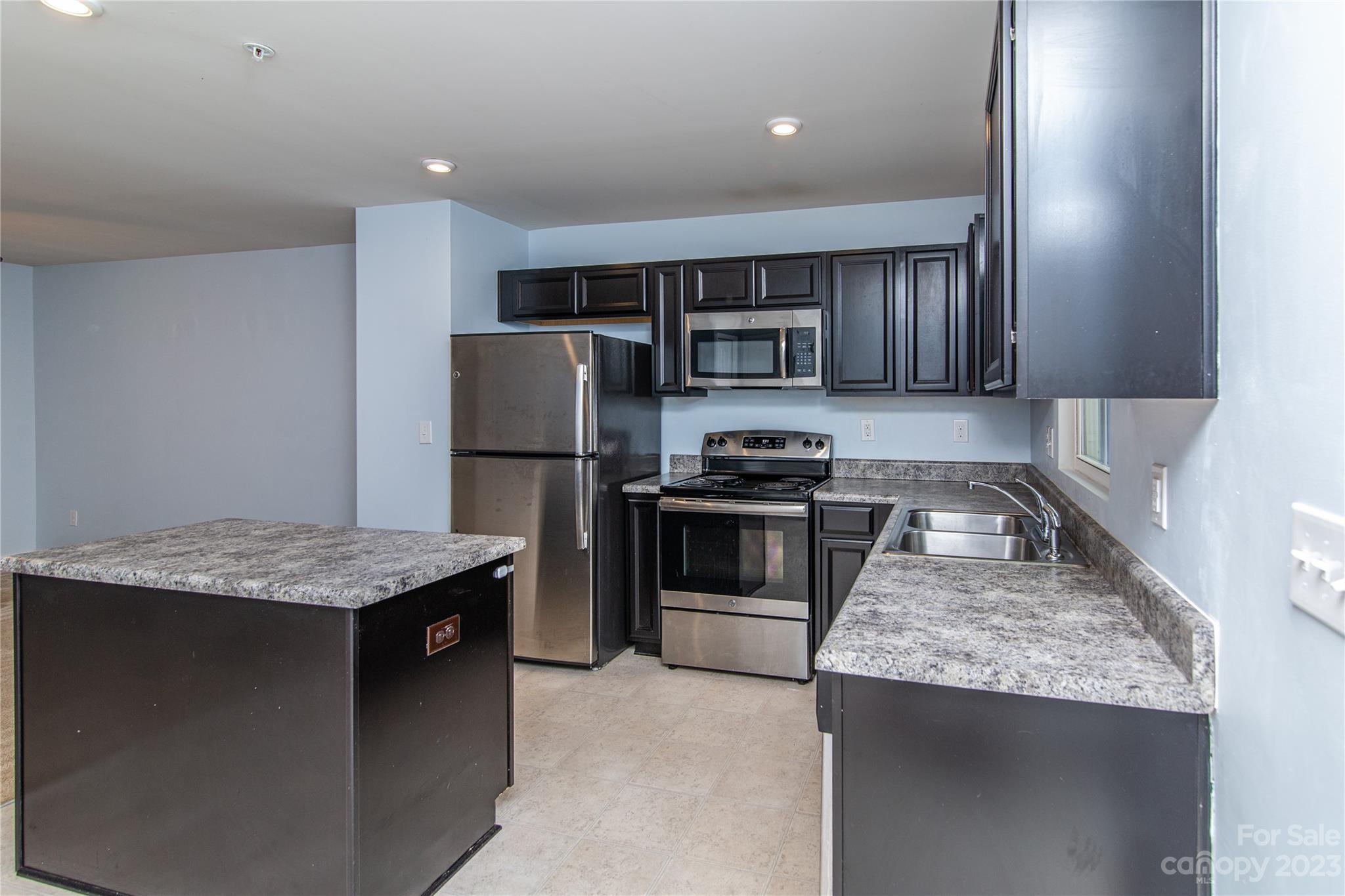 1151 Tangle Ridge Drive Southeast Concord, NC 28025 - Photo 8 of 22 a kitchen with stainless steel appliances granite countertop a sink stove and refrigerator