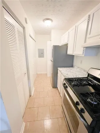 a kitchen with granite countertop a stove and a refrigerator