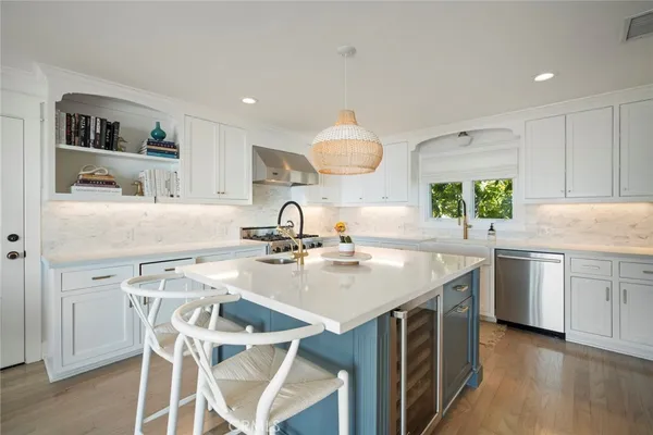 a kitchen with a table chairs sink and cabinets