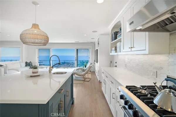 a kitchen with stainless steel appliances a sink a stove and a wooden floors