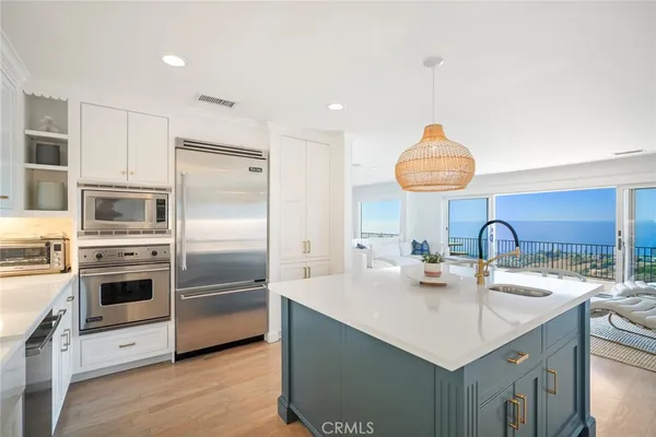 a kitchen with stainless steel appliances a sink a stove and refrigerator