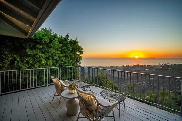 a view of a balcony with wooden floor and outdoor seating
