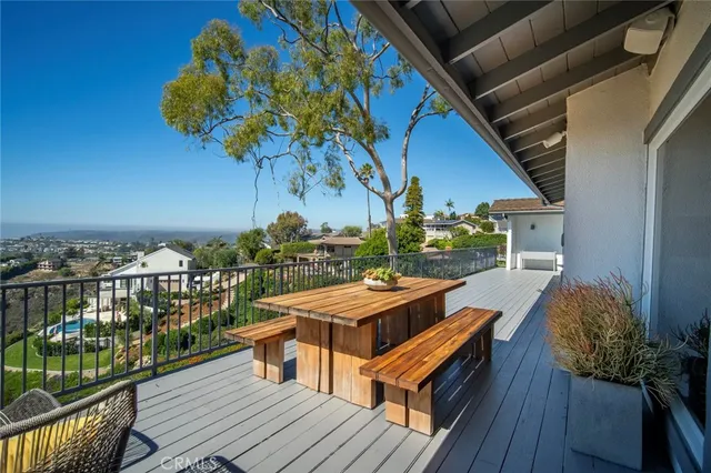 a balcony with wooden floor table and chairs