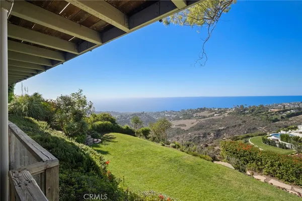 a view of a big yard with potted plants and mountain view in back