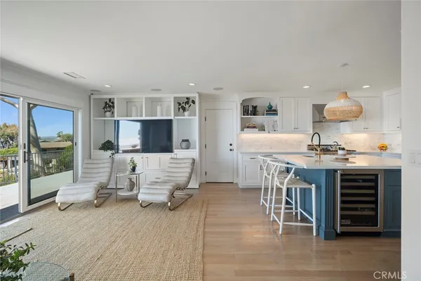 a living room with furniture a flat screen tv and kitchen view