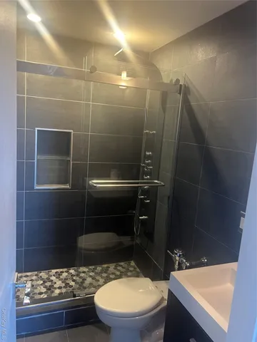 a bathroom with a sink a toilet and a shower
