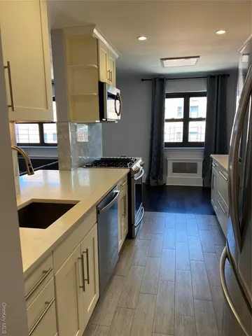 a kitchen with stainless steel appliances granite countertop a sink and wooden cabinets