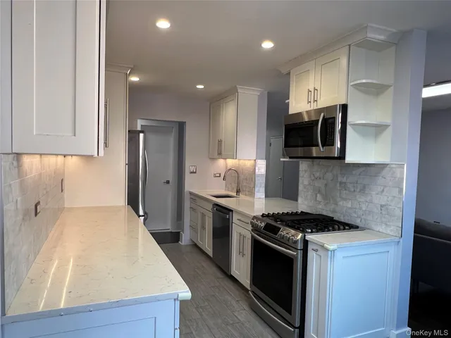 a kitchen with stainless steel appliances a stove microwave and refrigerator