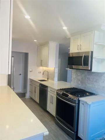 a kitchen with stainless steel appliances granite countertop a stove and a sink
